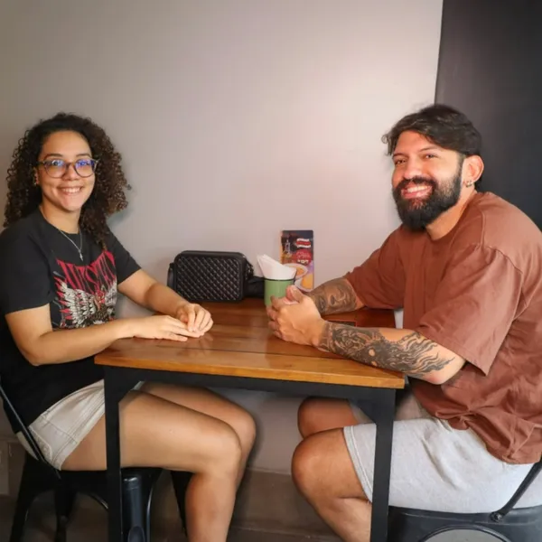 Dois clientes sorrindo à mesa do salão do Salatta em Caruaru