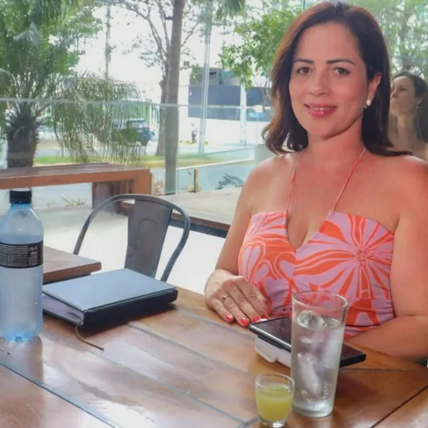 Cliente sorrindo na área externa do Salatta, com vista para a avenida